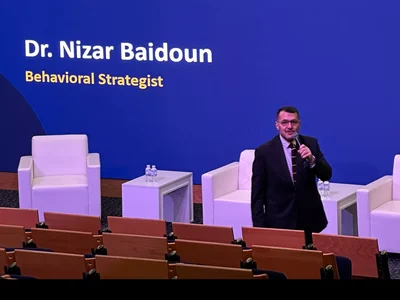 Dr. Nizar Baidoun on stage at GUST, below the title slide Communication That Works